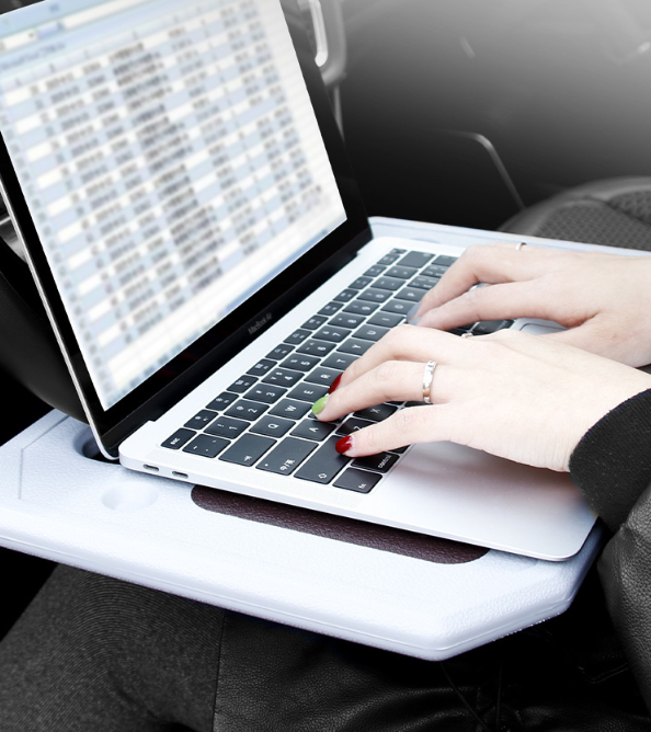 Steering wheel tray used as a laptop desk in a parked car