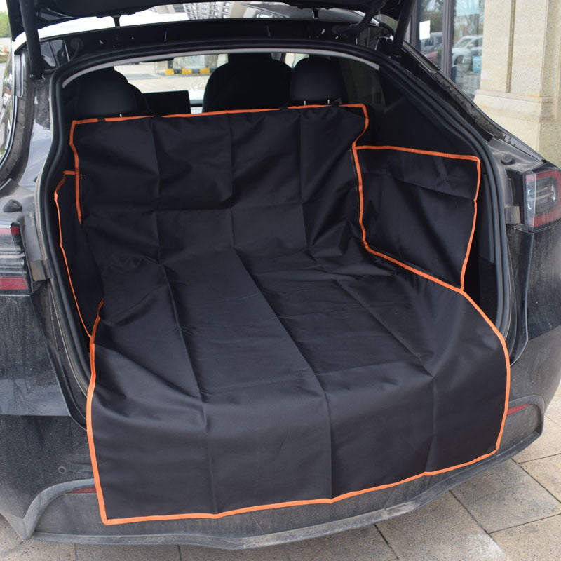 Dog sitting on a black cargo liner in an SUV trunk - view 2